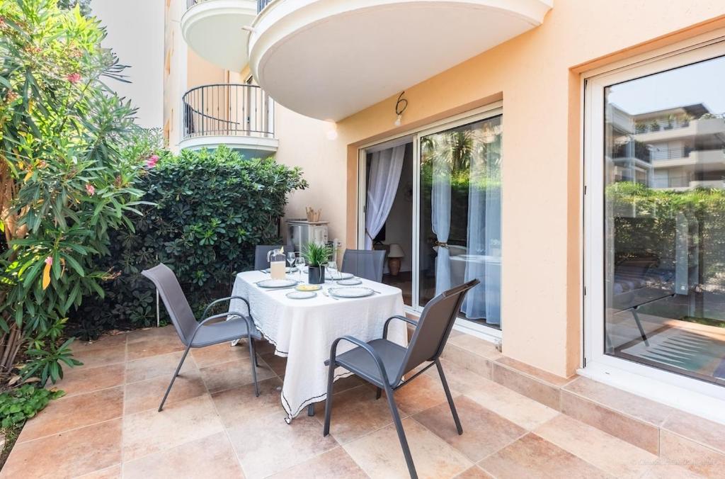 un tavolo e delle sedie sul patio di una casa di Saint Raphael appartement 4 étoiles neuf en rez de jardin privatif a Saint-Raphaël