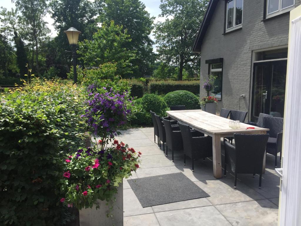 a patio with a table and chairs and flowers at Bed en Breakfast De Kees in Eersel