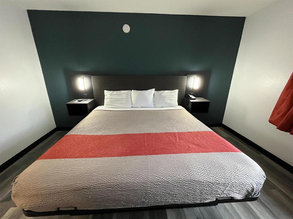 Un dormitorio con una cama grande con dos mesitas de noche. en Studio 6 Suites Urbana, IL, en Urbana