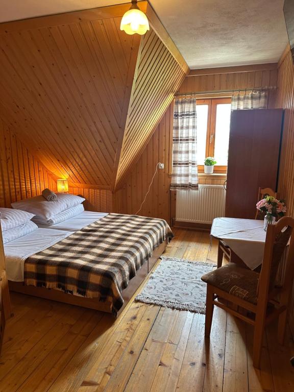 a bedroom with two beds and a table and a window at Pokoje Gościnne Stołowe in Gliczarów Górny