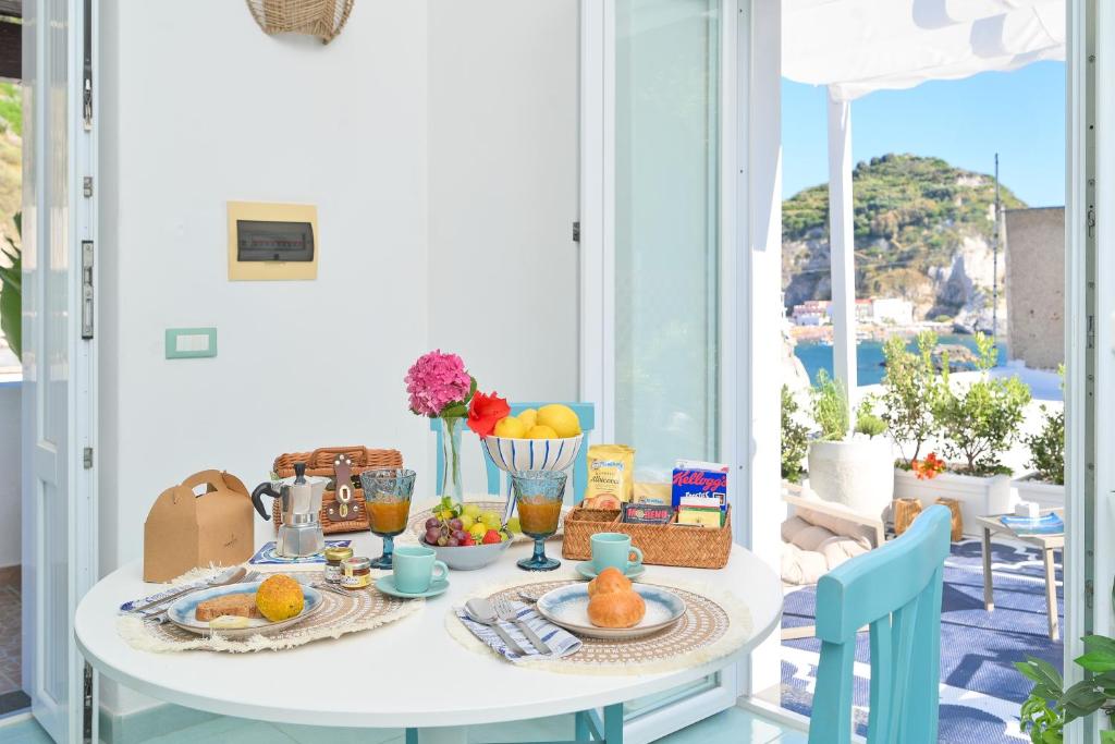 a breakfast table with food and a view of the ocean at Chiaia Di Rose Seaside Suite in Sant'Angelo D'Ischia