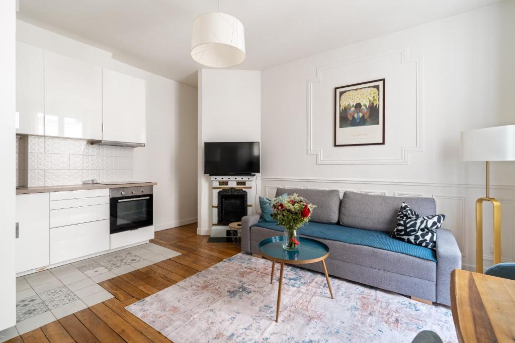 una sala de estar con un sofá y una mesa en Arc de Triomphe Magnifique appartement, en París