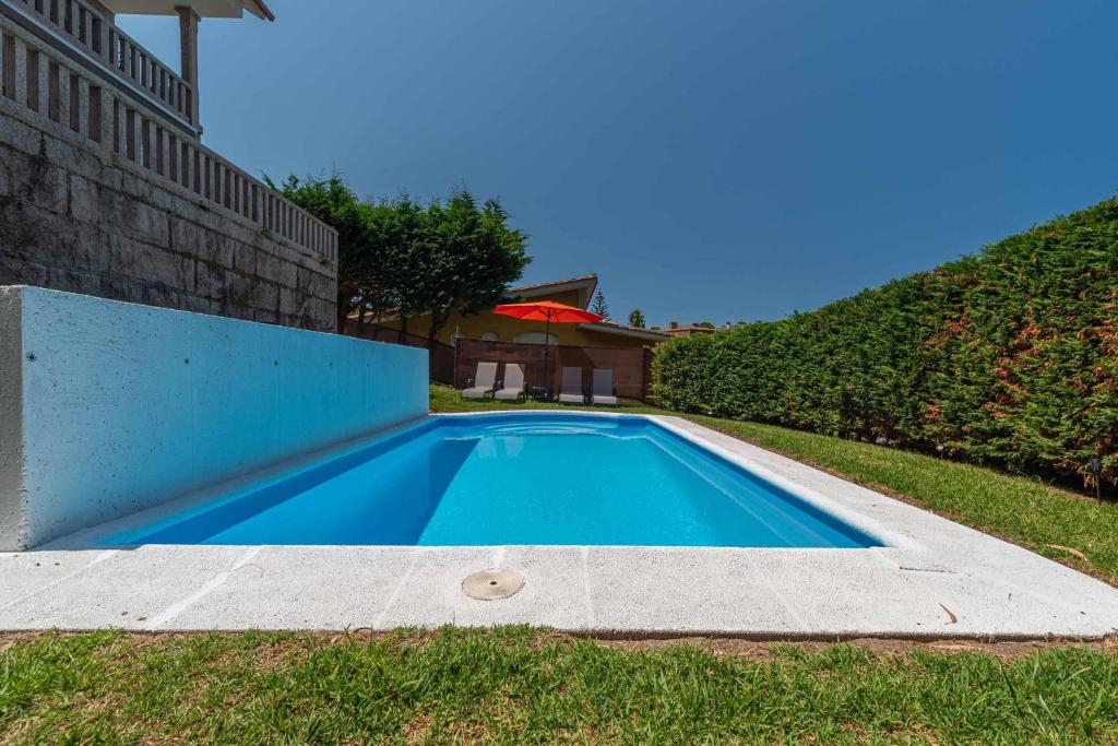a swimming pool in the yard of a house at Villa Cies con Piscina in Vigo