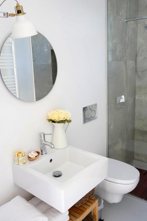 a white bathroom with a sink and a mirror at Sparrow Sintra Nest in Sintra