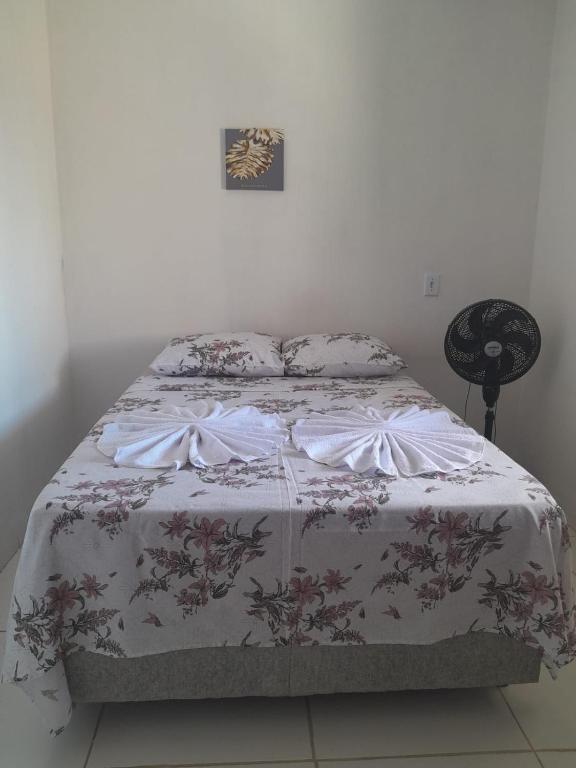 a bedroom with a bed with a floral bedspread at hospedagem dos viajantes in Lençóis