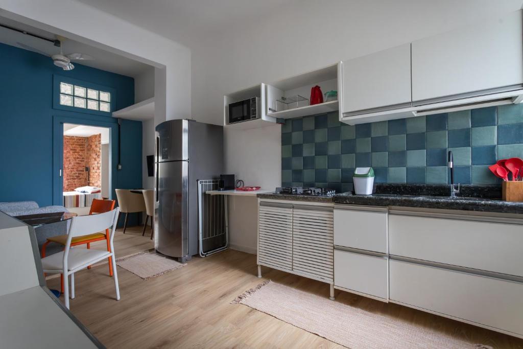 una cocina con armarios blancos y azulejos azules en Apartamento com Ar-Condicionado, en Salvador