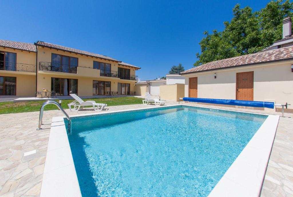 a swimming pool in front of a house at Motel Kolo in Buna