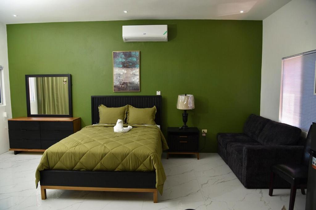 a bedroom with a bed with a cat sitting on it at LS Stonethrow - Emerald Cottage in Montego Bay