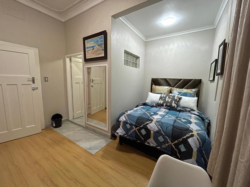 un dormitorio con una cama y un espejo en The Elegant Retreat of The Silver Room, en Johannesburgo