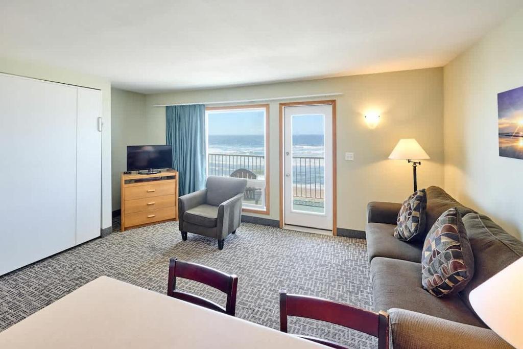 a living room with a couch and a chair at Corner Oceanview King Suite Full Kitchen Beach Access Pool & Hot Tub in Lincoln City