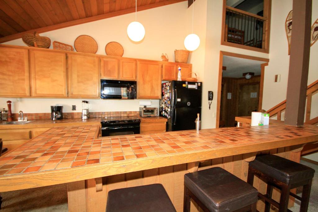 eine Küche mit einer großen Holztheke mit Stühlen in der Unterkunft Mountainback #40, Loft, Corner in Mammoth Lakes