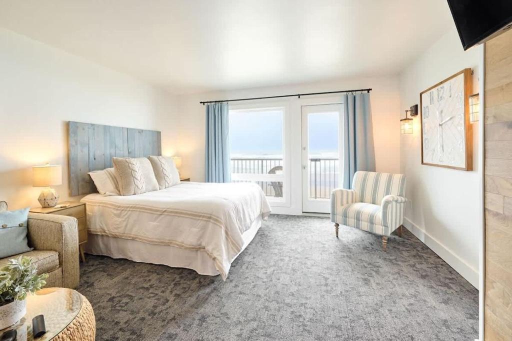 a bedroom with a bed and a chair and a window at Deluxe Suite for 6 King Bed & Ocean Views Pool and Hot Tub in Lincoln City