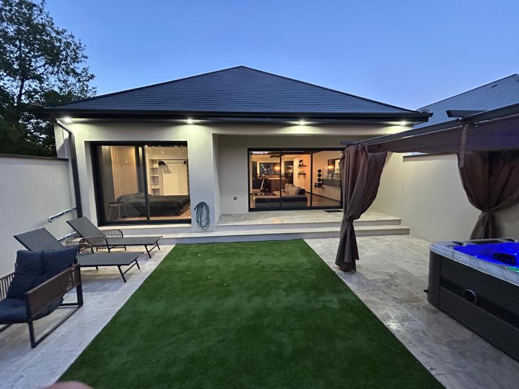 a house with a green lawn in the backyard at Maison SPA 2025 in Mont-près-Chambord