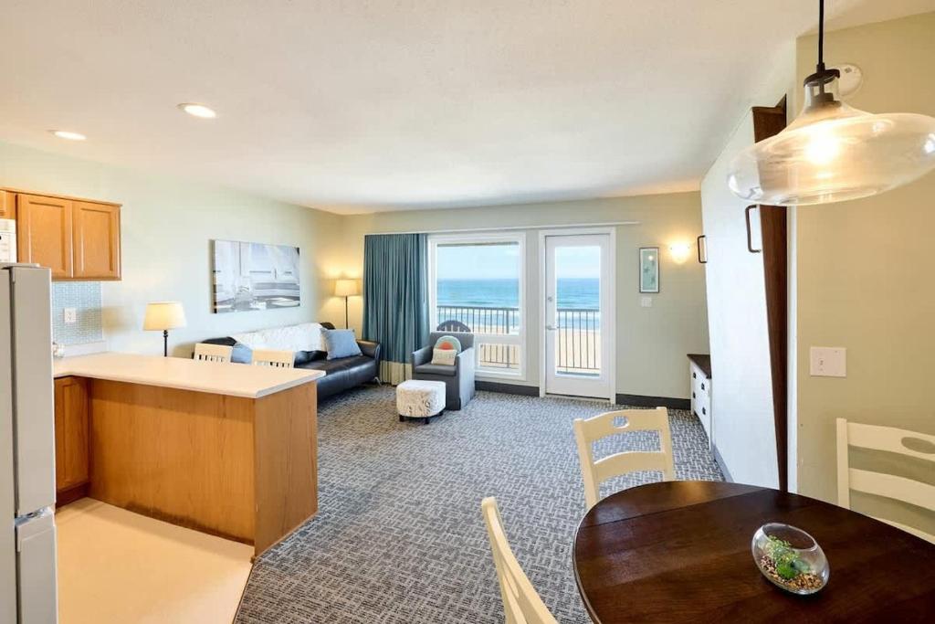 a living room with a kitchen and a living room with a couch at Oceanfront Family Suite - Full Kitchen - Beach Access - Pool & Hot Tub in Lincoln City
