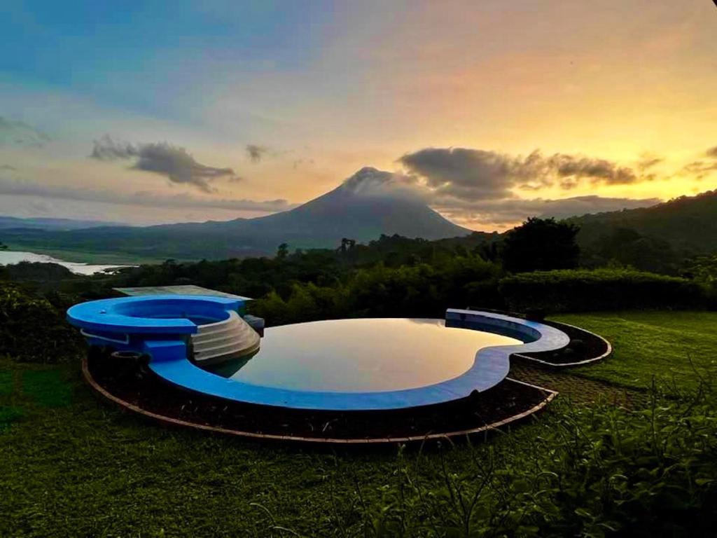una piscina nell'erba con una montagna sullo sfondo di Serenity House Panoramic Views And Swimming Pool, a El Castillo de la Fortuna