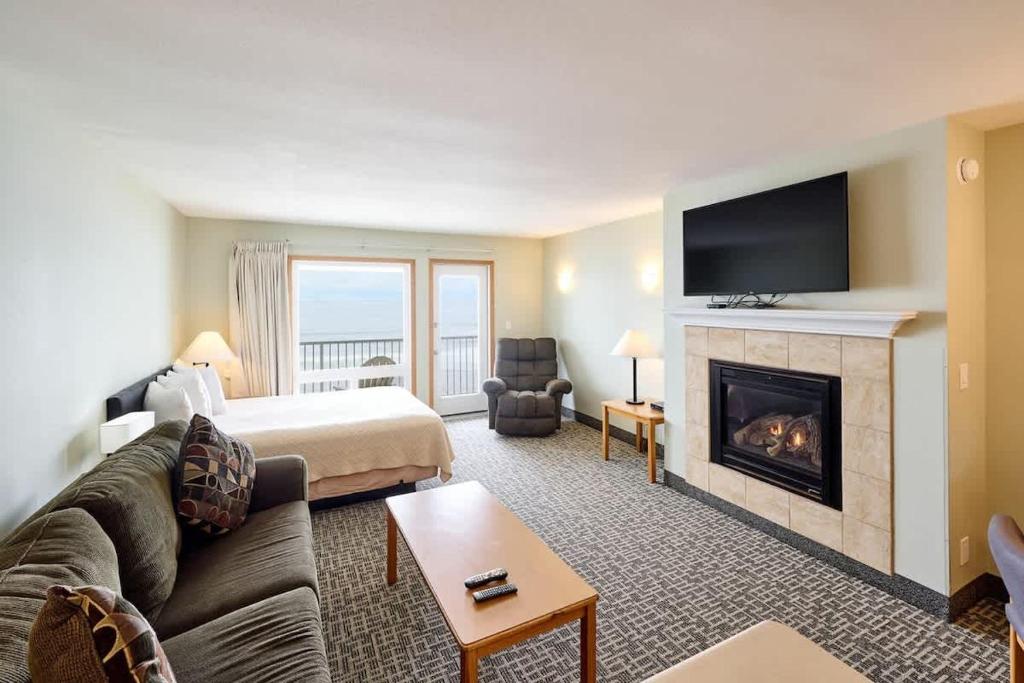 ein Wohnzimmer mit Couch und Kamin in der Unterkunft Top-Floor Deluxe Suite With Ocean View - Sleeps Six in Lincoln City