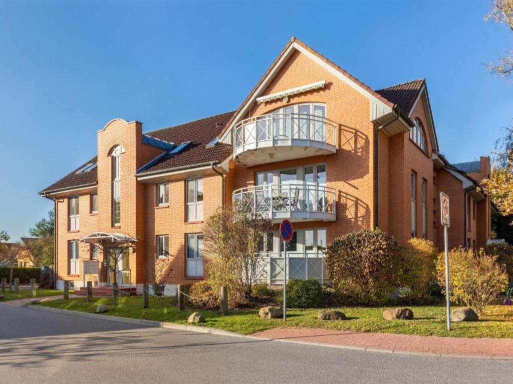 a brick house with a balcony on a street at Friederike in Tarnewitz