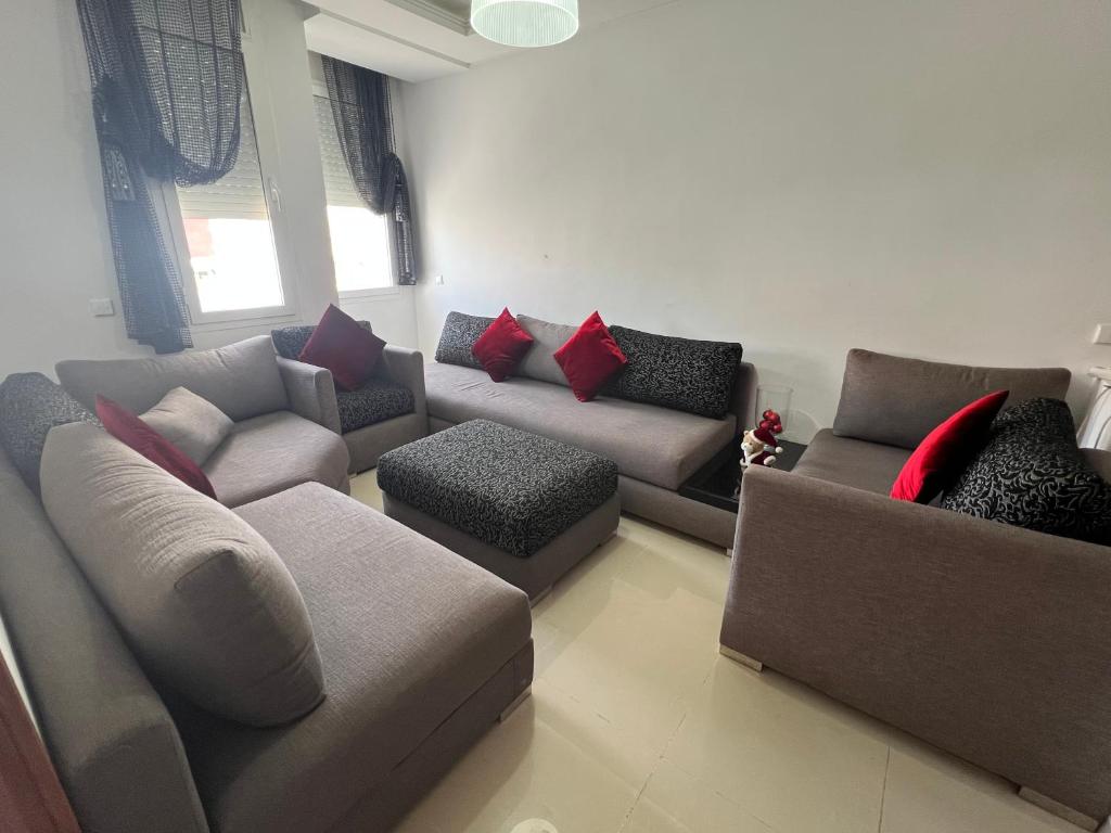 a living room with couches and red pillows at Résidence Al Massira Fnideq in Fnidek