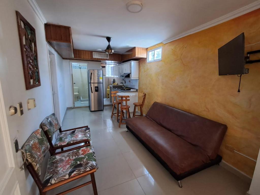 a living room with a couch and a kitchen at Apartaestudio en el Rodadero junto al mar in Gaira
