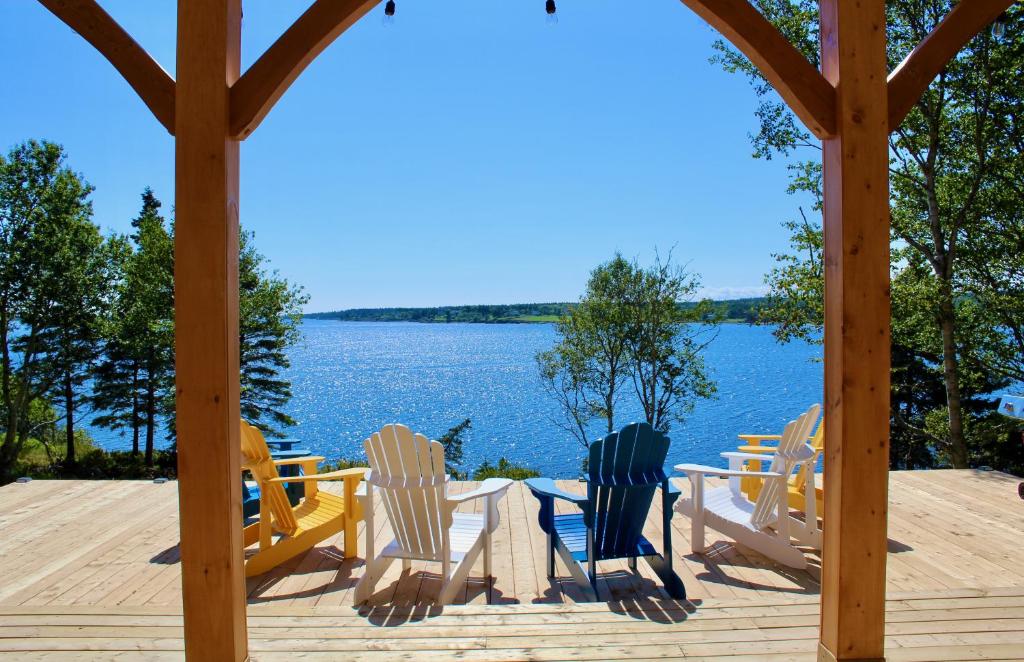 eine Sitzgruppe auf einem Deck neben dem Wasser in der Unterkunft Whitecaps Retreat Beach House 