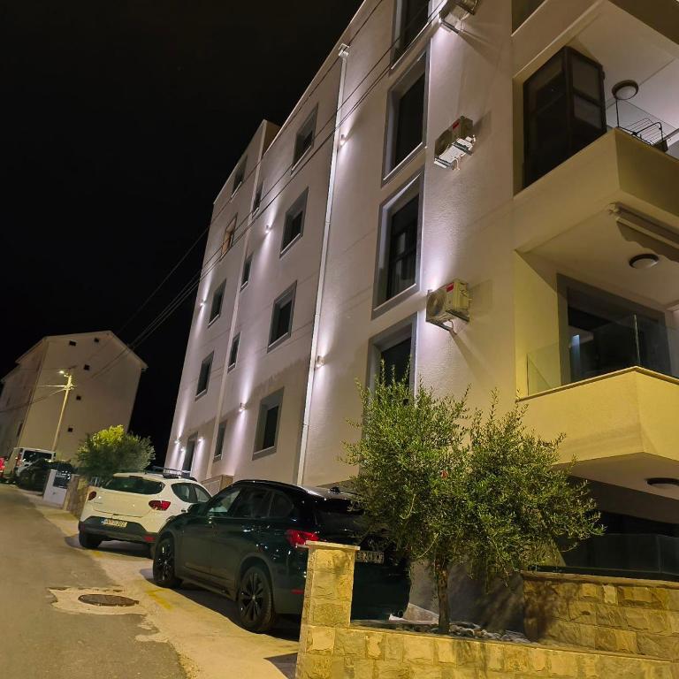 a building with cars parked in front of it at night at Blue Bay Boutique Studio in Đenovići