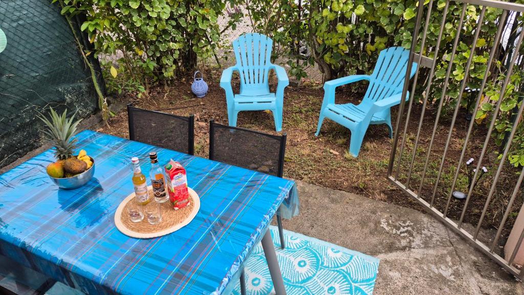 レ・トロワ・イレにあるTI BLUE plage à proximitéの青い椅子2脚と飲み物が置かれたテーブル