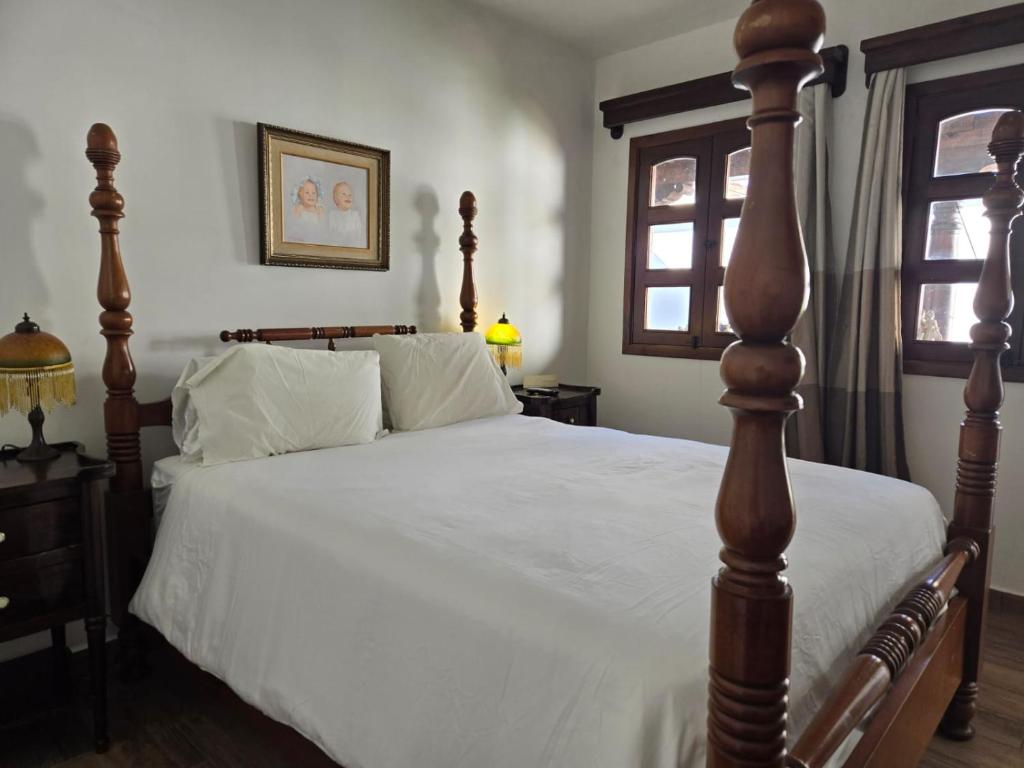 a bedroom with a large bed with a wooden post at Casa Alina in Antigua Guatemala
