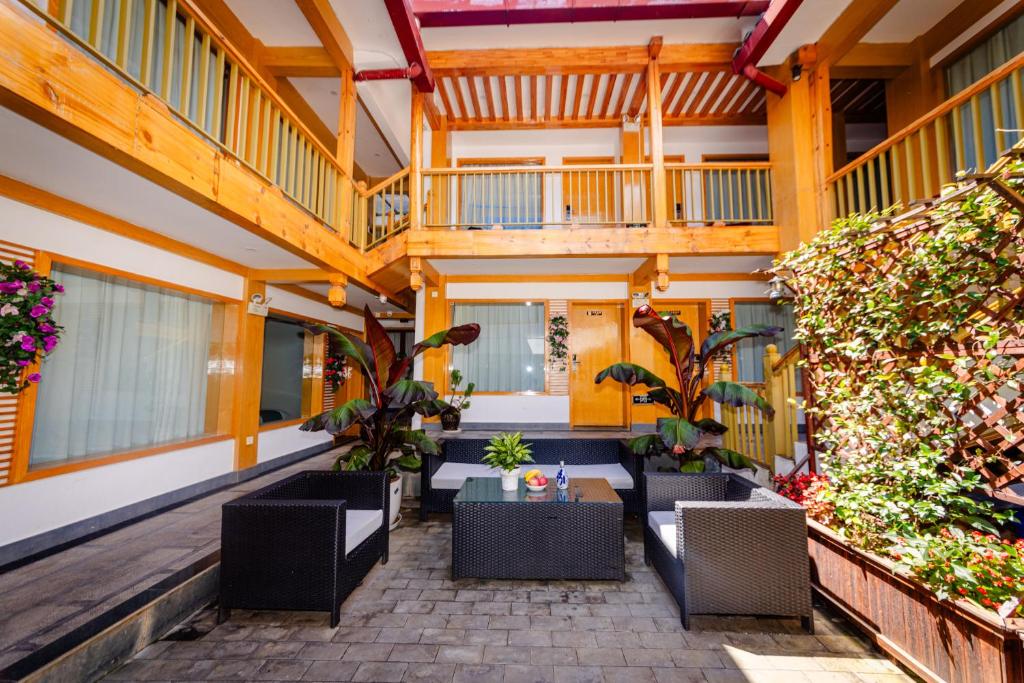 Un patio al aire libre con mesas y sillas en un edificio. en Lijiang Tongfu Inn, en Lijiang