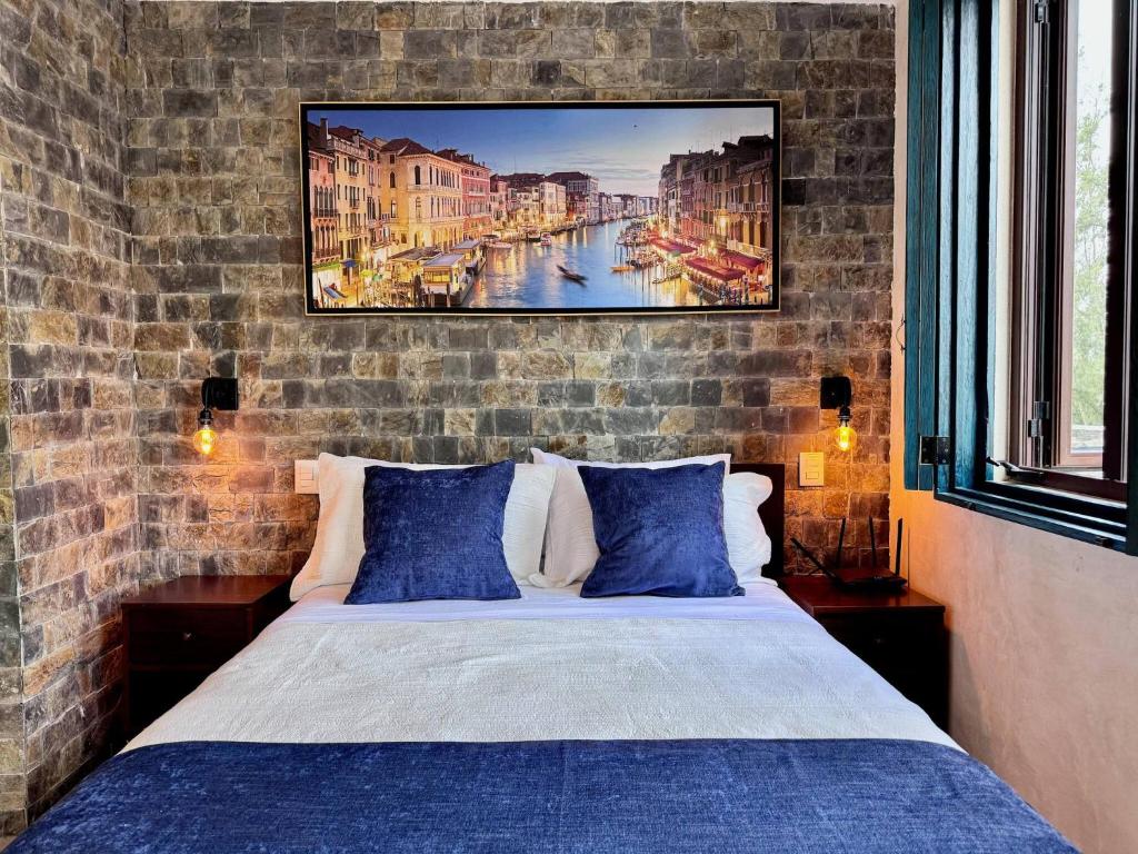 a bedroom with a bed and a painting on the wall at Venezia 2 en ValQuirico in Santeagueda