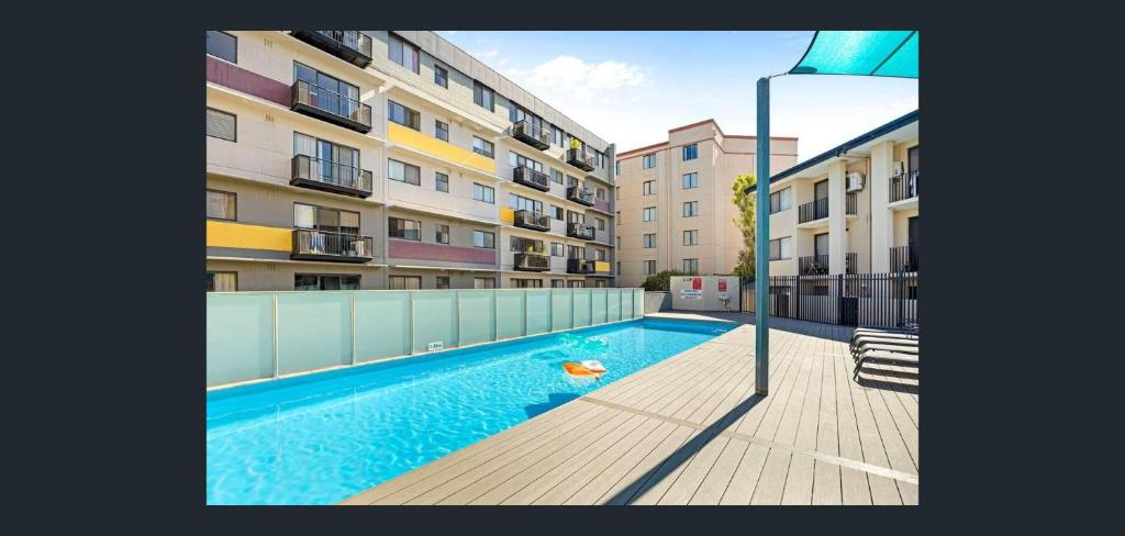 a swimming pool in front of a apartment building at East Perth Apartment Suites with Parking in Perth