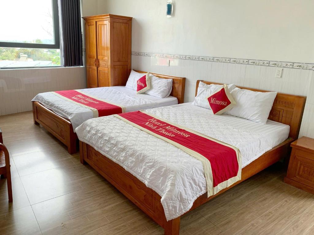 two beds in a hotel room with sidx sidx sidx sidx at Mimosa 7 Hotel - Phan Rang in Phan Rang–Tháp Chàm