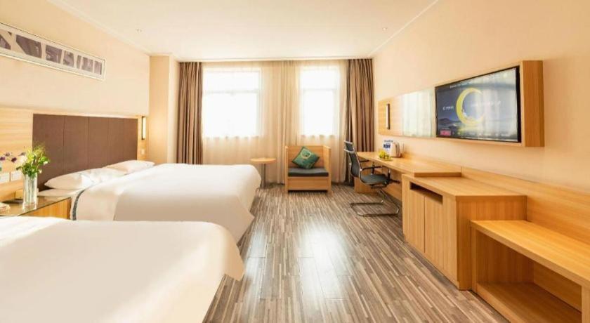 une chambre d'hôtel avec deux lits et un bureau dans l'établissement City Comfort Inn Hefei Shuanggang Fuyang Road, à Hefei