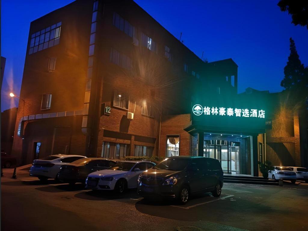 a group of cars parked in front of a building at GreenTree Inn Express Shanghai Baoshan District Youyi Road Metro Station in Baoshan