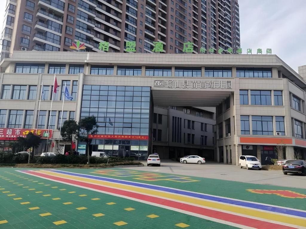 a large building with cars parked in front of it at GreenTree Alliance Hotel Suzhou Dangshan Lihua Square in Dangshan