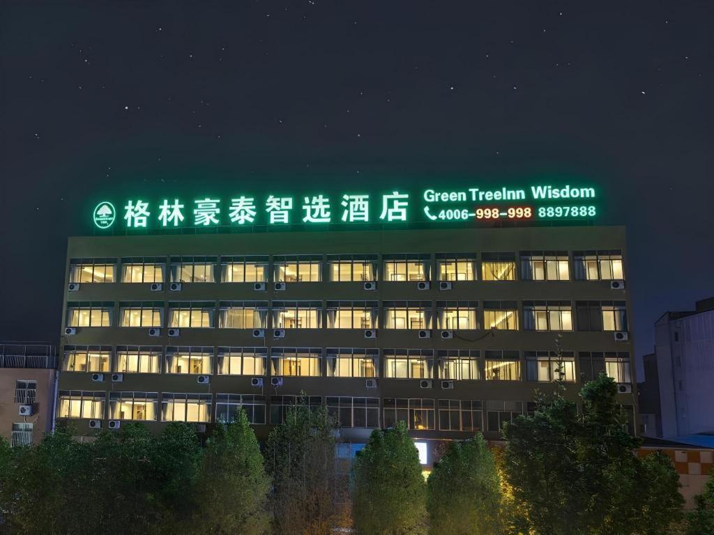 a building with a green sign on top of it at GreenTree Inn Express Shandong Zaozhuang Shizhong District Huashan Road Ginza in Zaozhuang