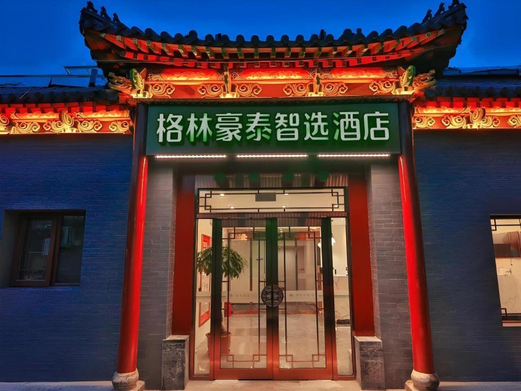 une entrée à un bâtiment avec un panneau sur celui-ci dans l'établissement GreenTree Inn Express Beijing Dongcheng District Beixinqiao Metro Station Gui Street, à Pékin