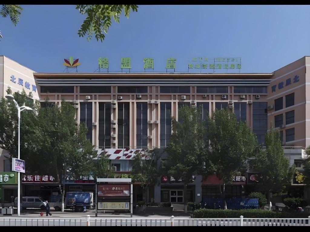 a building with a sign on top of it at GreenTree Alliance Hotel Qinghuangdao Wanda Plaza in Qinhuangdao