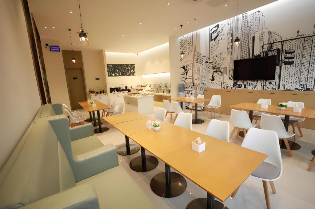 a restaurant with tables and chairs and a tv at City Comfort Inn Dong'an Avenue County Government in Guzhuting