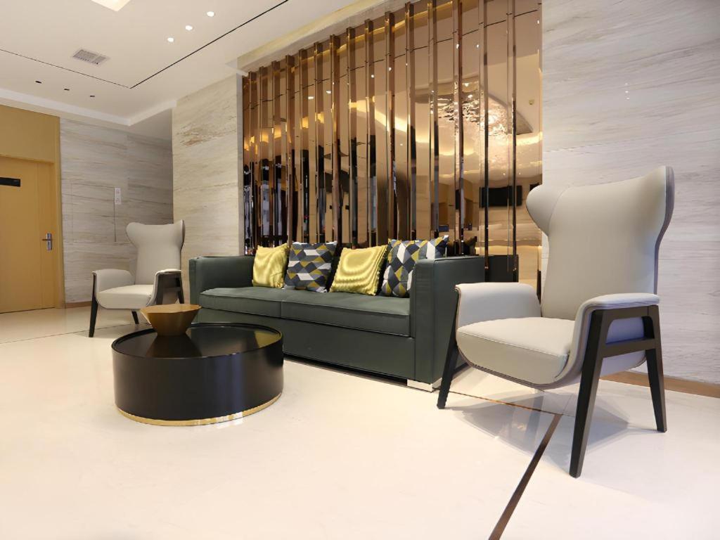 a living room with a couch and two chairs at City Comfort Inn Dalian Changxin Dao Santang Commercial Street in Wafangdian