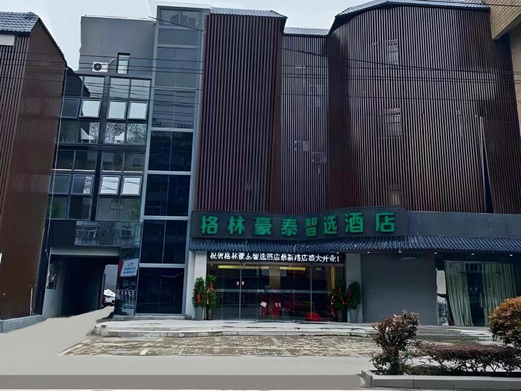 a building with a sign on the front of it at Green Tree Inn Express Huainan Xiejiaji District Orient Guangji Hospital in Huainan