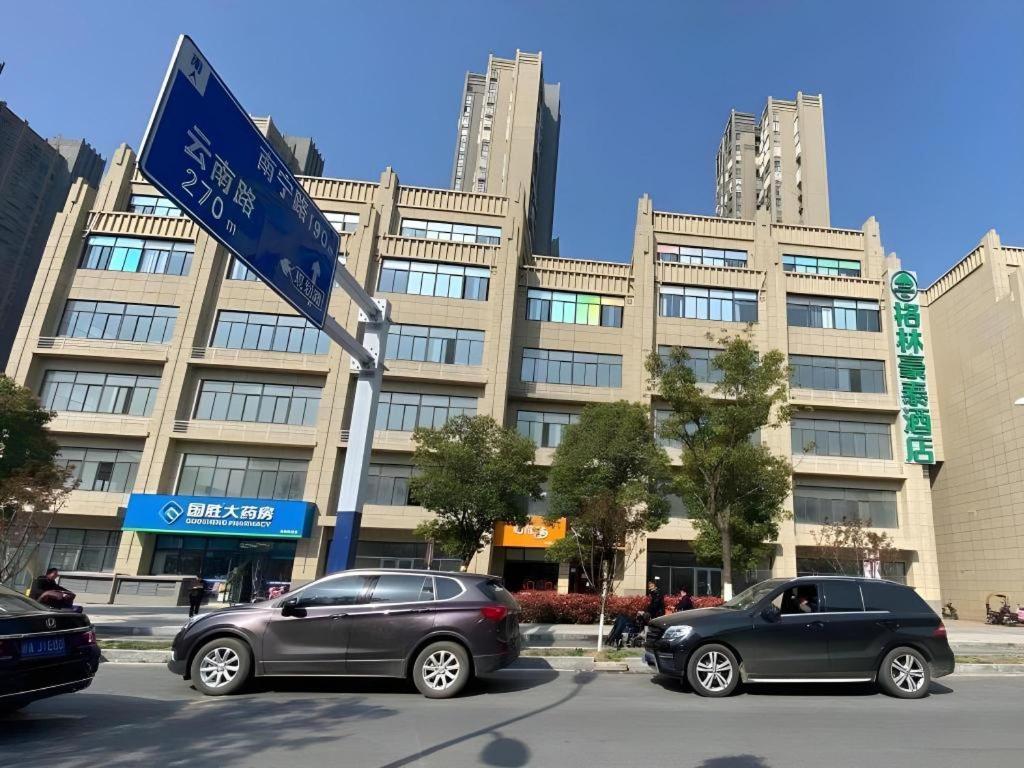 two cars parked in front of a building with a street sign at Green Tree Inn Anhui Hefei Binhu Zhuyuan Metro Station Dali Road in Hefei