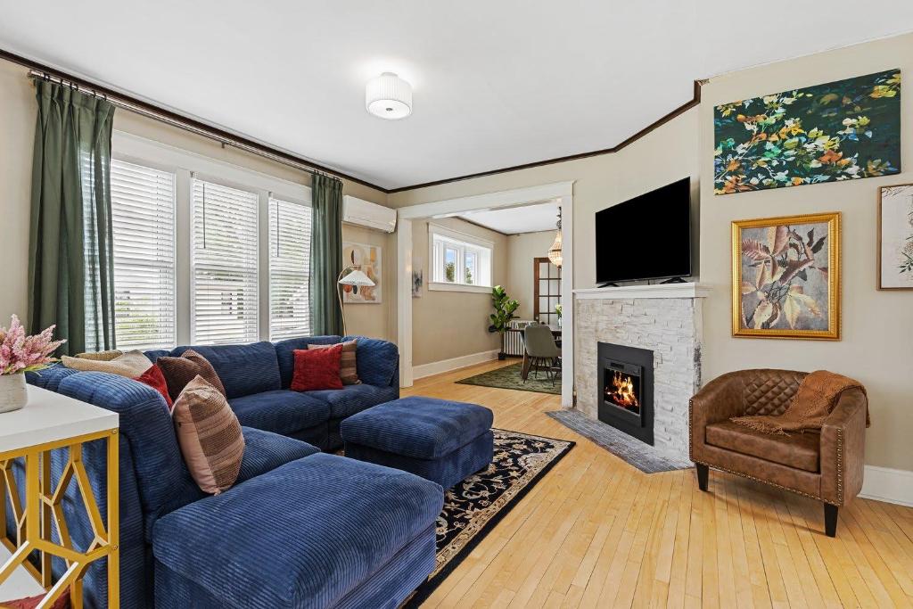 een woonkamer met een blauwe bank en een open haard bij ArtGallery PrivateHotTub Sauna NearMountRushmore FamilyHome in Rapid City