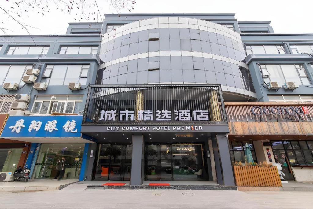 a large building with signs in front of it at Premier City Comfort Hotel Yangzhou Shouxi Lake West Gate Weiyang Road Siji Garden in Yangzhou