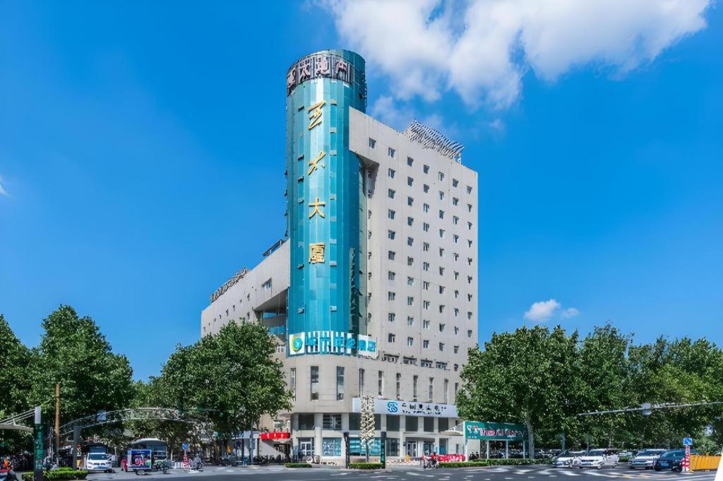 un bâtiment avec une tour bleue au sommet dans l'établissement City Comfort Inn Handan New Century Plaza, à Sucao