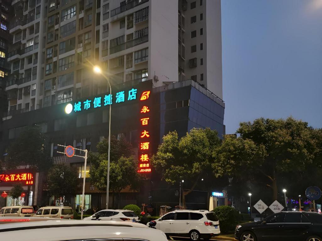 une rue de la ville avec des voitures garées devant des bâtiments dans l'établissement City Comfort Inn Chongqing Yongchuan Xuefu Avenue Wanda, à Yongchuan