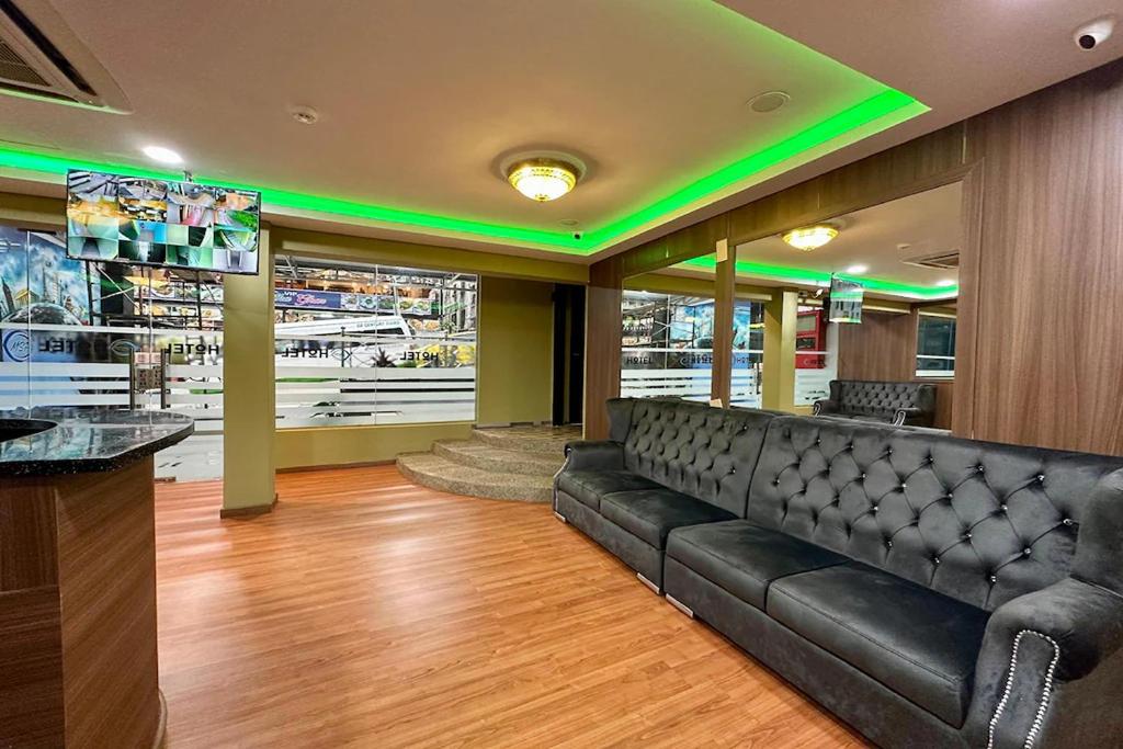 a waiting room with a black leather couch and green lights at Hotel MSP Bukit Bintang in Kuala Lumpur