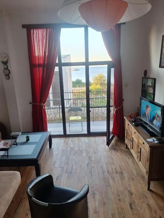 a living room with a large window and a couch at Sea view apartment in Tsarevo