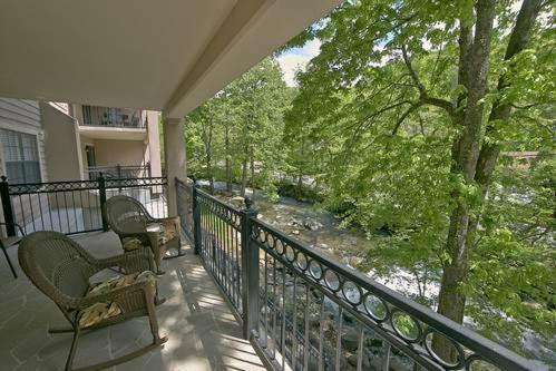 d'un balcon avec deux chaises et une vue sur la rivière. dans l'établissement Gatehouse Condos - 106 Holiday home, à Gatlinburg