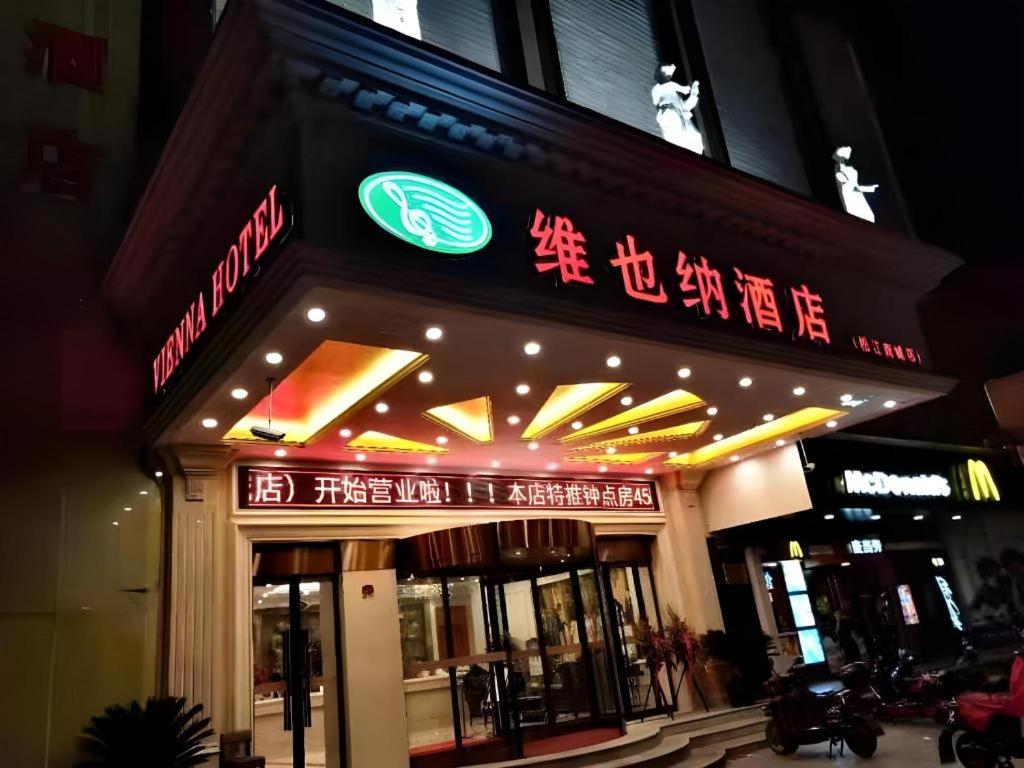 un magasin avec des enseignes au néon sur la devanture dans l'établissement Vienna Hotel Shanghai Songjiang Market Miaoqian Street, à Chengxi