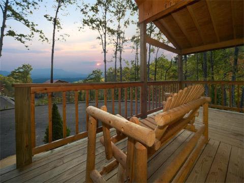 une chaise à bascule en bois assise sur une terrasse en bois dans l'établissement A Slice of Heaven Holiday home, à Sevierville
